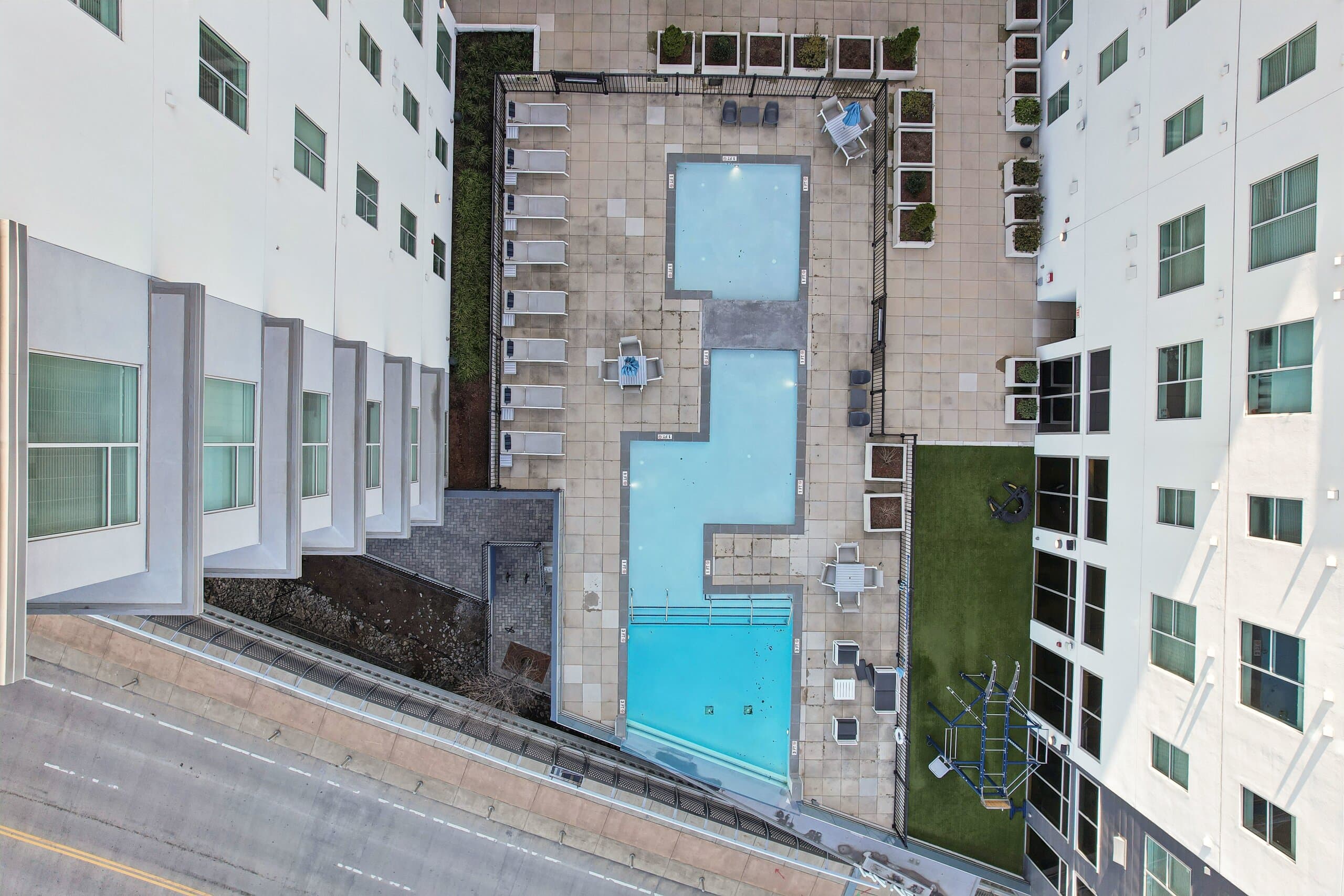 The pool deck seen straight down from above, loungers along its edge